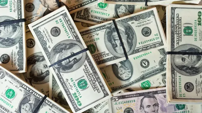Billetes de dólar apilados y organizados con bandas elásticas.