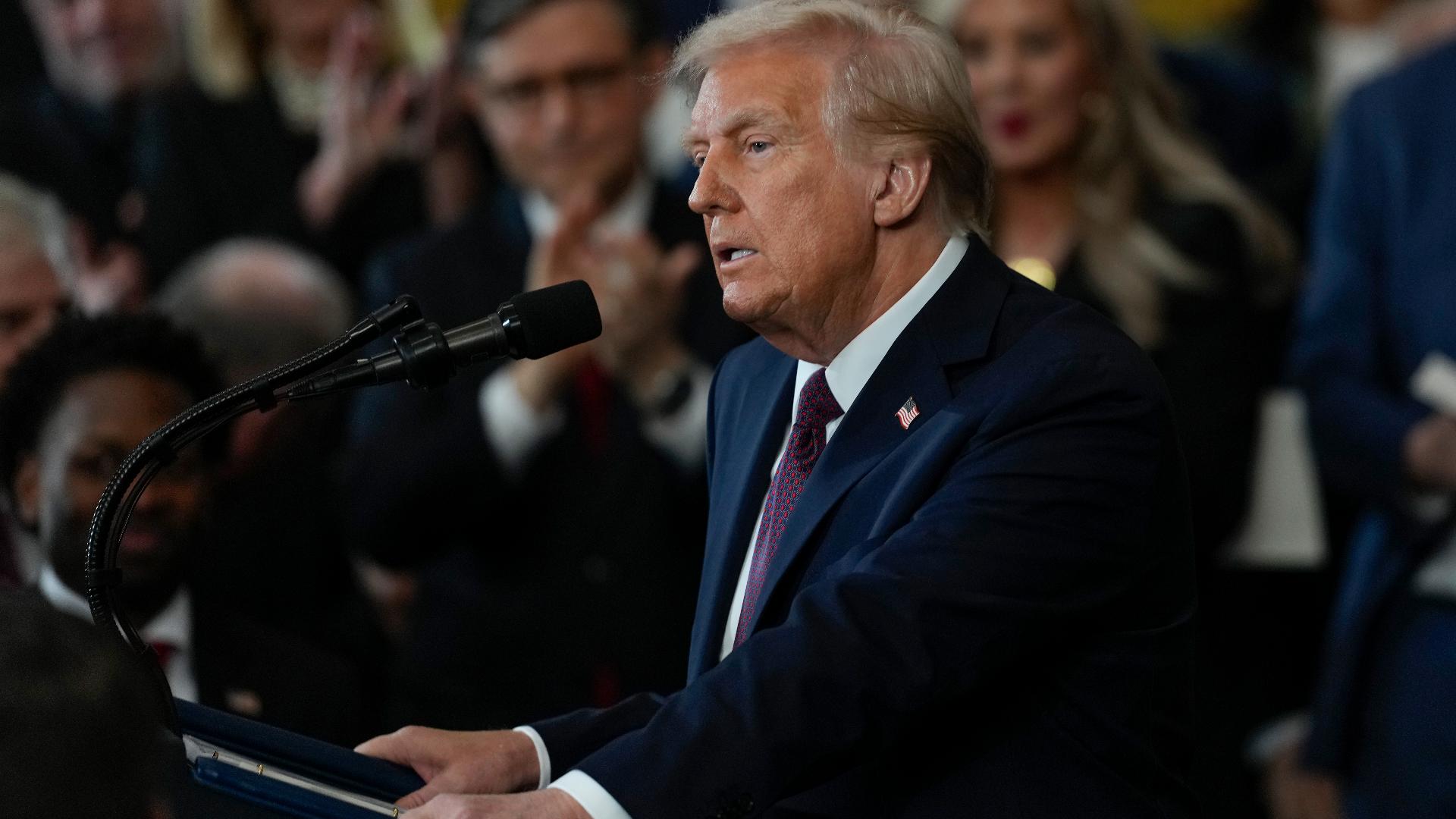 Donald Trump anunciando medidas de política migratoria en un evento, con auditorio al fondo.