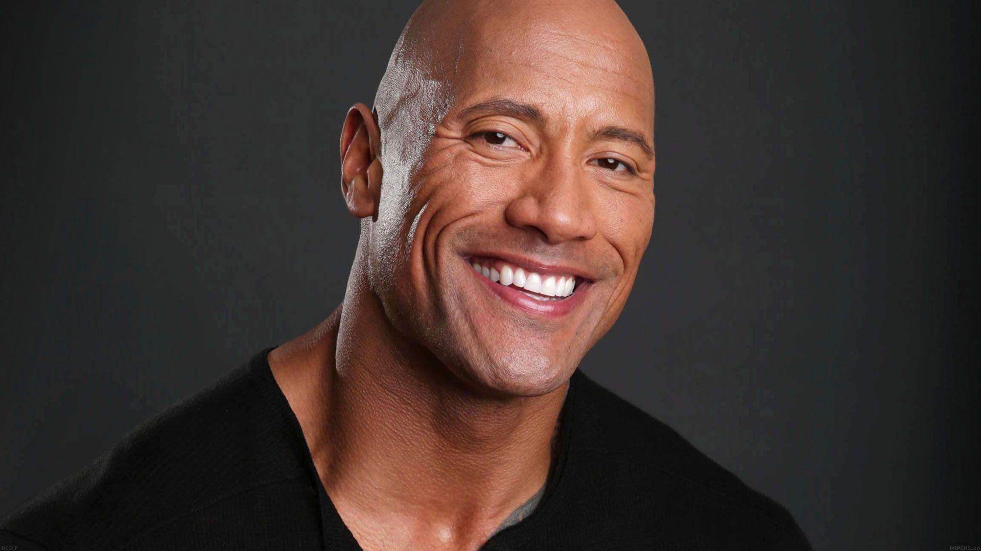Dwayne Johnson sonriente con fondo oscuro