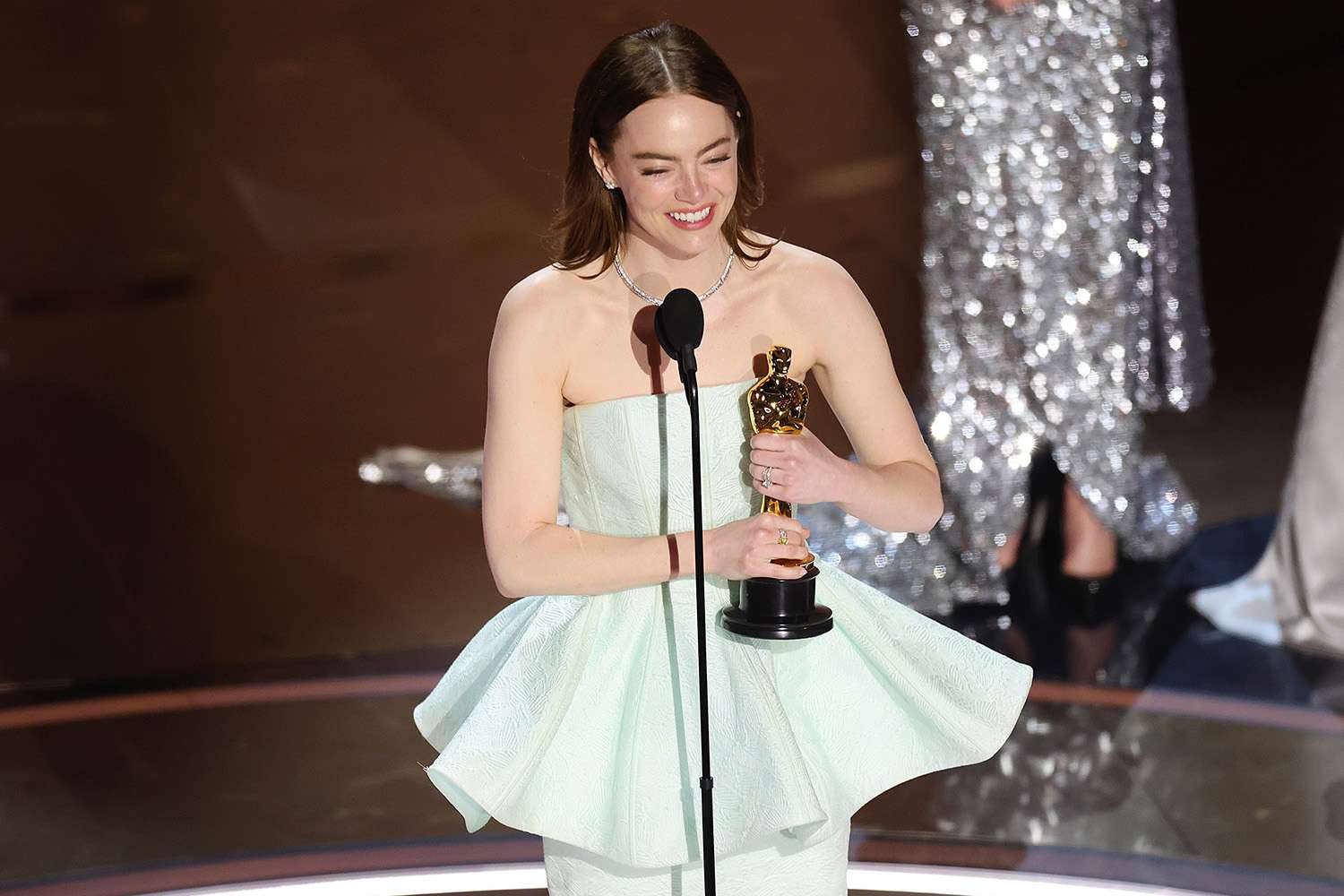 Emma Stone recibiendo un Óscar en un evento de premiación.