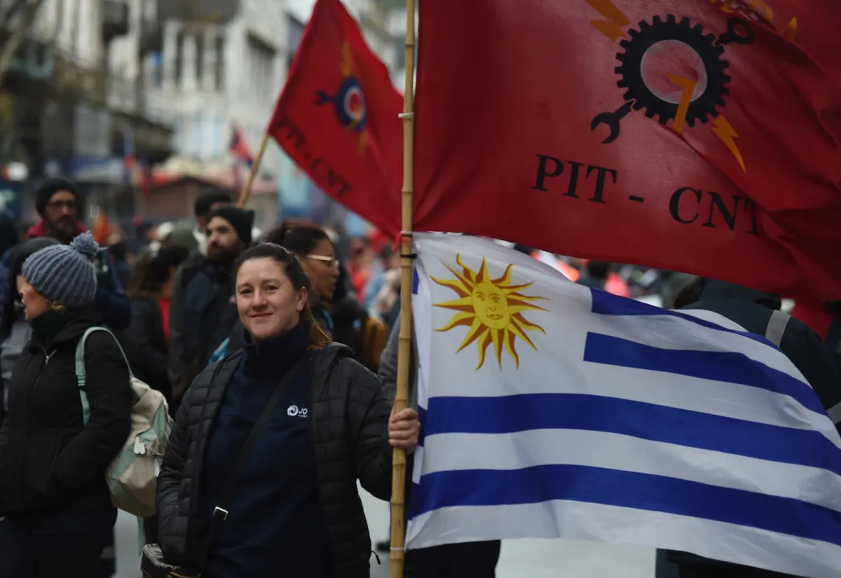 Manifestantes con banderas del PIT-CNT y Uruguay en una marcha.