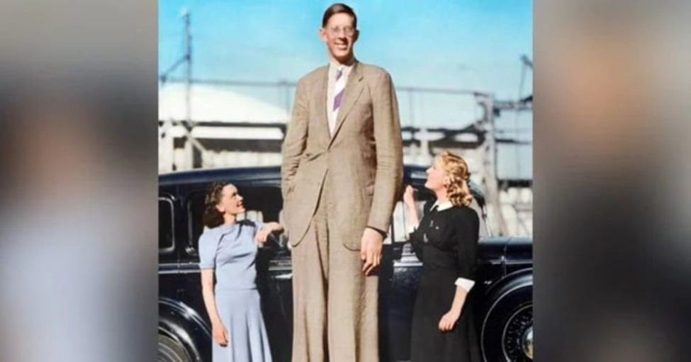 Robert Wadlow junto a dos mujeres y un automóvil antiguo.