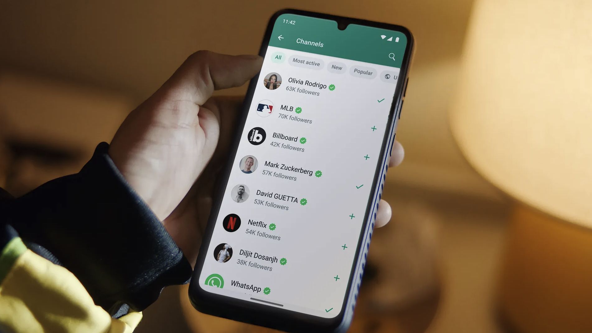 Usuario sosteniendo un smartphone con WhatsApp en pantalla