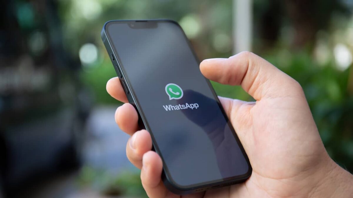 Una mano sostiene un smartphone mostrando la aplicación de WhatsApp.